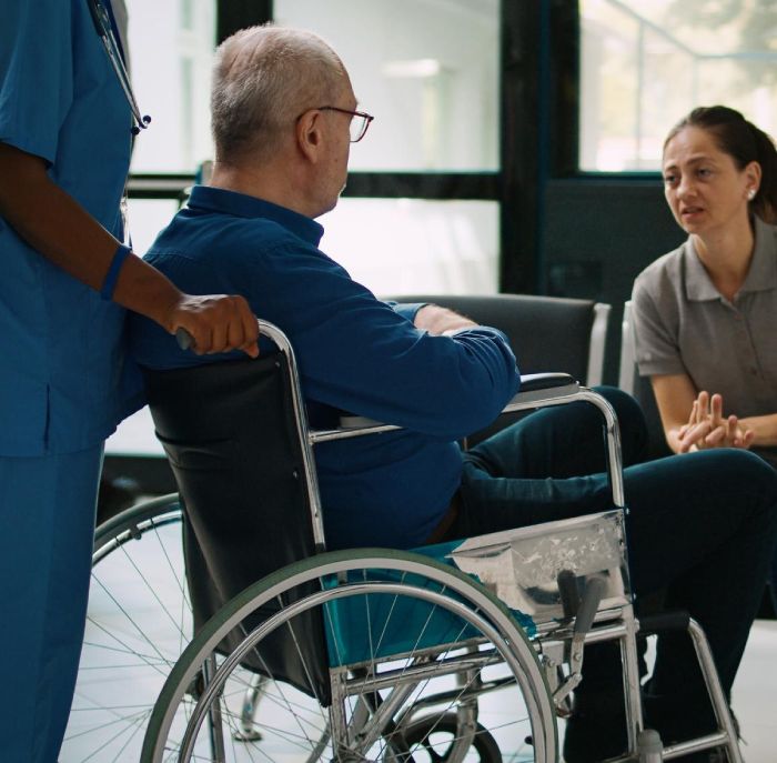 Nurse helping elderly man in wheelchair